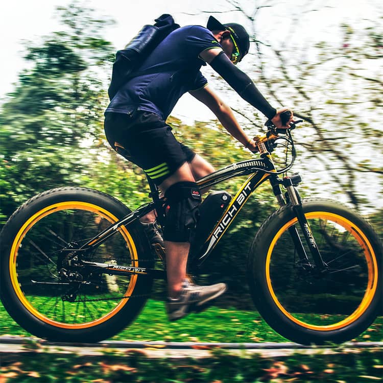 rider enjoy cycling of e-bike with brand RICHBIT on flat road